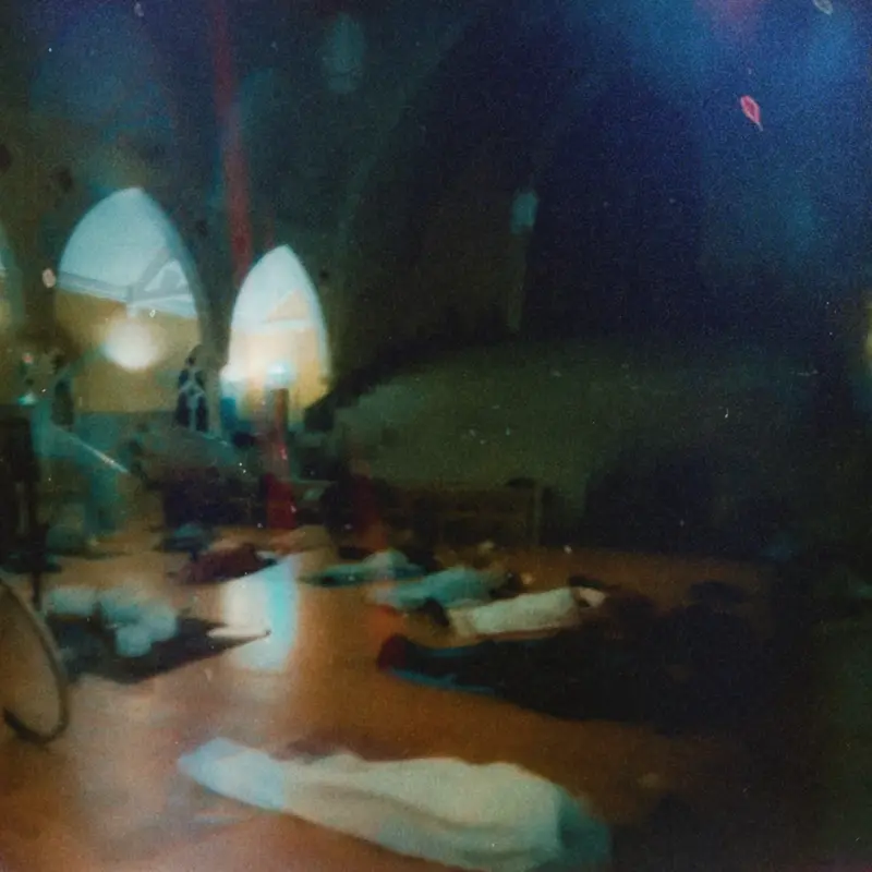 Atmospheric wide shot in a church hall with arched windows.